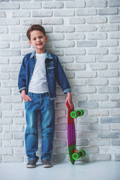 스케이트 보드와 카메라를보고 청바지 세련된 소년의 초상화 — 스톡 사진