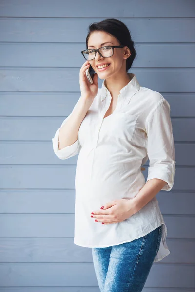Piękna Kobieta Ciąży Okulary Jest Rozmowy Telefon Komórkowy Trzymając Jedną — Zdjęcie stockowe