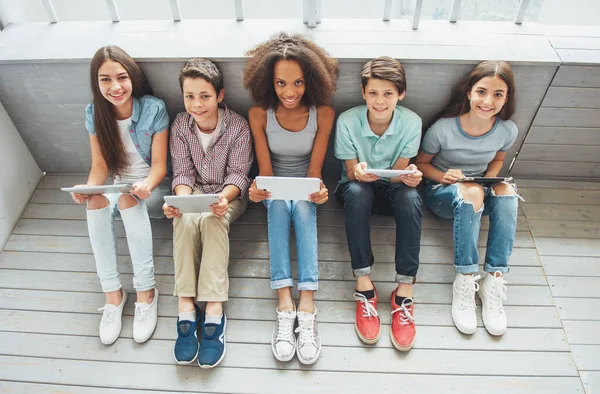 Genç Erkek Kız Grup Tablet Kullanarak Kameraya Bakıyor Ahşap Zemin — Stok fotoğraf