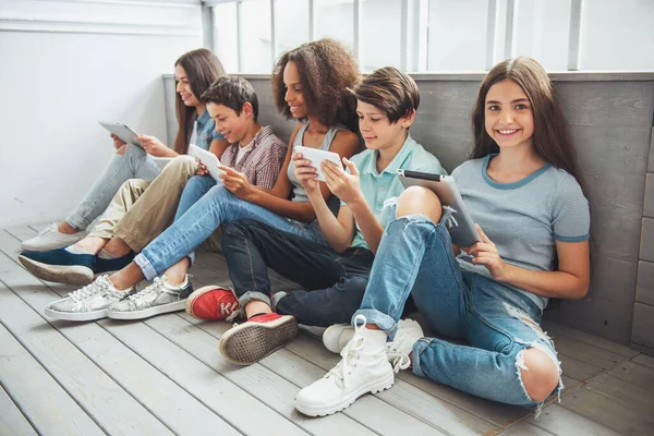 Genç Erkek Kız Grup Tablet Kullanarak Ahşap Zemin Üzerinde Otururken — Stok fotoğraf