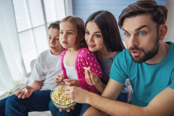 Piękne Młode Rodzice Ich Córka Syn Oglądają Telewizję Jedząc Popcorn — Zdjęcie stockowe