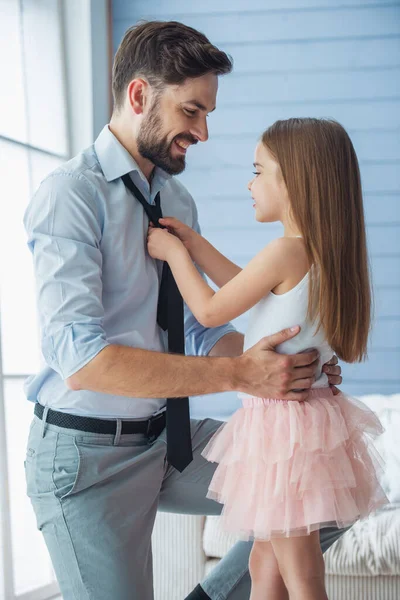 可爱的小女儿调整她父亲的领带 两人都笑容满面 站在房间里 — 图库照片