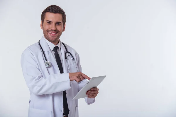 Schöner Arzt Weißen Kittel Benutzt Ein Tablet Blickt Die Kamera — Stockfoto