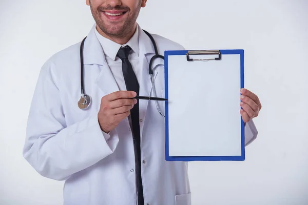 Skadrowana Przystojny Lekarz Białym Płaszczu Uśmiechający Się Trzymając Folder Wskazujące — Zdjęcie stockowe