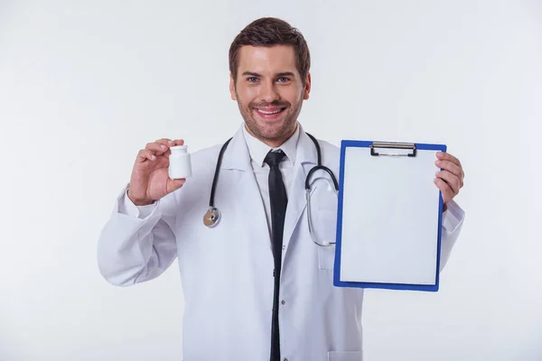 Yakışıklı Doktor Beyaz Paltolu Bir Klasör Bir Şişe Ilaç Kameraya — Stok fotoğraf