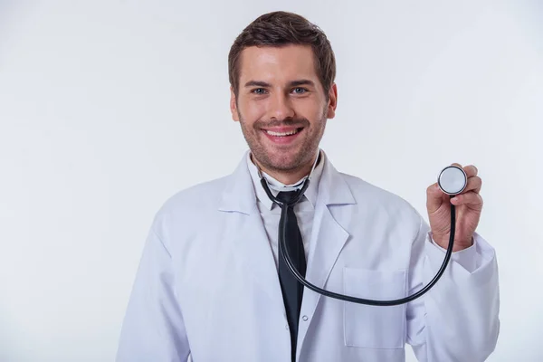 Portret Przystojny Lekarz Białym Płaszczu Patrząc Kamery Uśmiechnięty Przytrzymanie Stetoskop — Zdjęcie stockowe