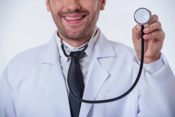 Skadrowana Przystojny Lekarz Białym Płaszczu Uśmiechający Się Trzymając Stetoskop Izolowana — Zdjęcie stockowe