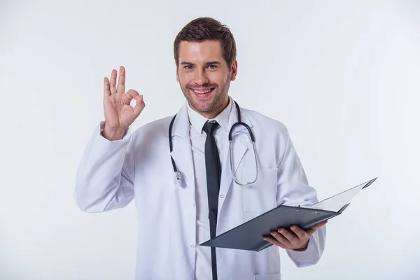 Portret Przystojny Lekarz Białym Płaszczu Posiadających Folder Wyświetlono Znak Patrząc — Zdjęcie stockowe