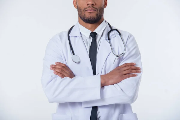 裁剪的图像的英俊非裔美国的医生就在白大衣站立时双臂交叉 在白色背景上孤立 — 图库照片