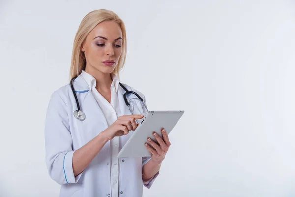배경에 태블릿을 사용하여 코트를 아름다운 의사의 초상화 — 스톡 사진
