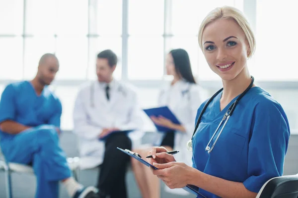 Beautiful Female Doctor Making Notes Looking Camera Smiling Background Three — Stock Photo, Image