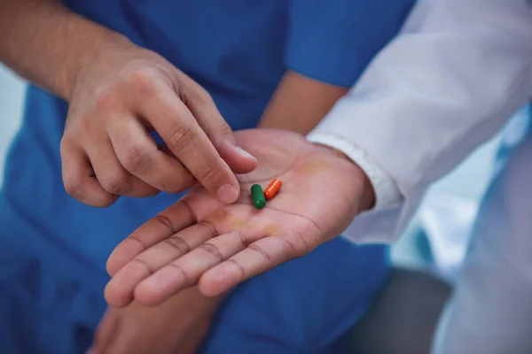 一人の医師は 別の医師の手のひらから薬を取っているクローズ アップ — ストック写真