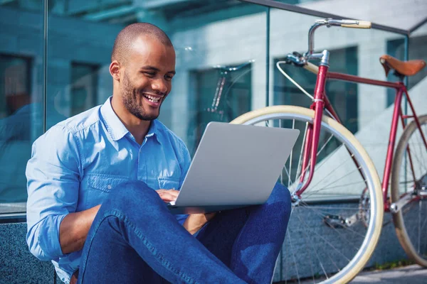 Bonito Jovem Empresário Está Usando Laptop Sorrindo Enquanto Está Sentado — Fotografia de Stock