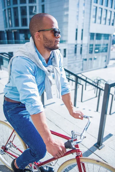 年轻英俊的商人 穿着休闲装 戴着太阳镜 骑在自行车上 憧憬着 — 图库照片