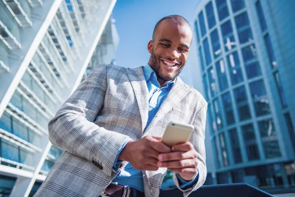 Kjekk Ung Forretningsmann Med Briller Bruker Smarttelefon Smiler Utendørs – stockfoto