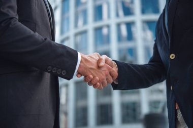 Karşılıklı iki genç işadamlarının Klasik takım elbiseli, arka planda bina ofis