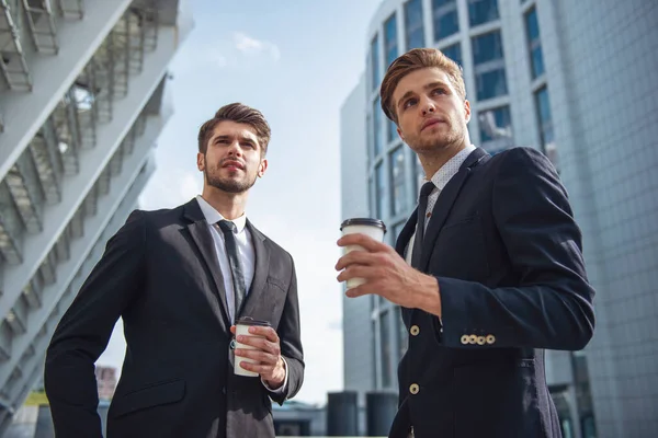 Baixo Ângulo Visão Dois Jovens Empresários Bonitos Ternos Clássicos Segurando — Fotografia de Stock
