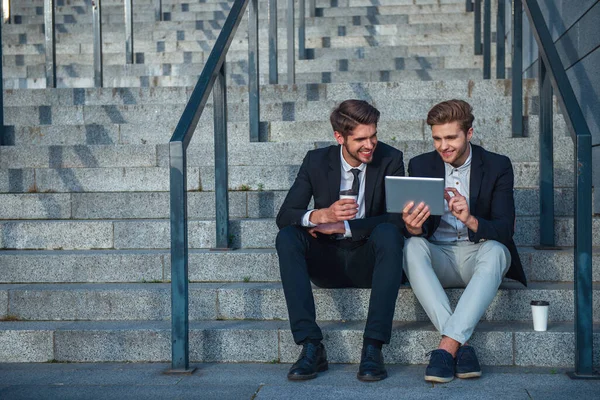 Dois Jovens Empresários Bonitos Roupas Formais Estão Usando Tablet Sorrindo — Fotografia de Stock