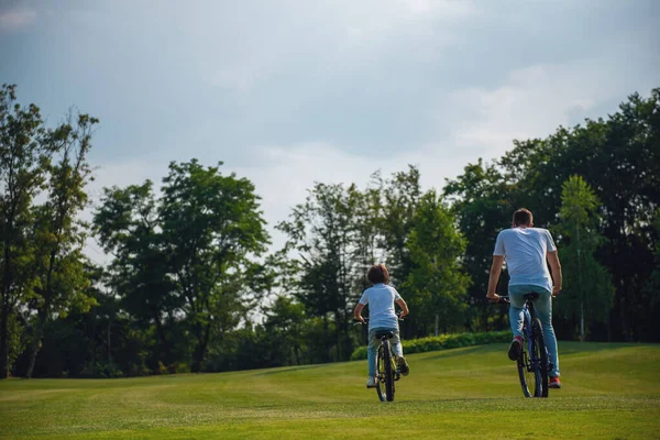 Arkadan Görünüşü Genç Baba Oğlunun Rahat Kıyafetler Bisiklet Park Içinde — Stok fotoğraf