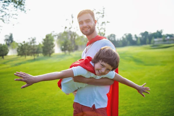 Süper Kahramanlar Kamera Seyir Parkta Oynarken Gülümseyen Yakışıklı Genç Baba — Stok fotoğraf