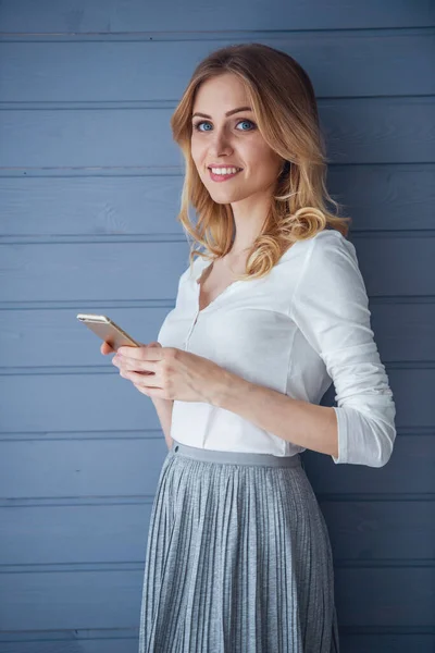 Όμορφη Νεαρή Γυναίκα Casual Ρούχα Είναι Κρατώντας Ένα Smartphone Κοιτάζοντας — Φωτογραφία Αρχείου