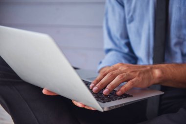 Klasik takım elbiseli bir dizüstü bilgisayar kullanarak süre çalışma, yakın çekim yakışıklı genç işadamı kırpılmış görüntü