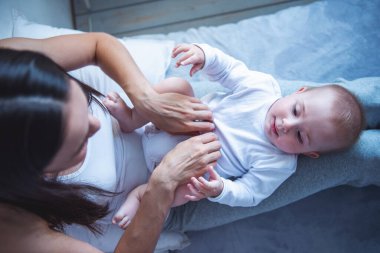 Güzel genç anne ve onun tatlı küçük bebek birbirine bakarak ve gülümseyerek, evde birlikte vakit Üstten Görünüm