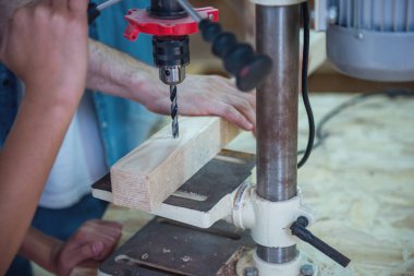 Yakışıklı marangoz ve ahşap ve delme makine atölyesinde çalışan oğlu Resim kırpılmış yakın çekim