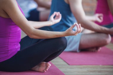 Lotus bulunduğu modern fitness salonunda yoga yaparken oturan güzel spor insanların kırpılmış görüntü