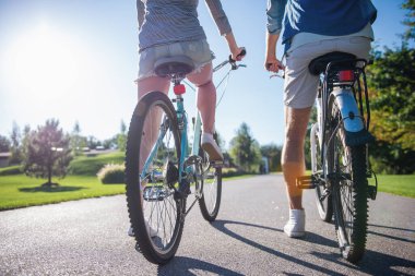 Kırpılmış parkta Bisiklete binme güzel şık çift arkadan görünüm