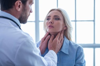 Yakışıklı doktor ofisinde çalışırken kadın hastanın Yaralı boyun incelenmesi