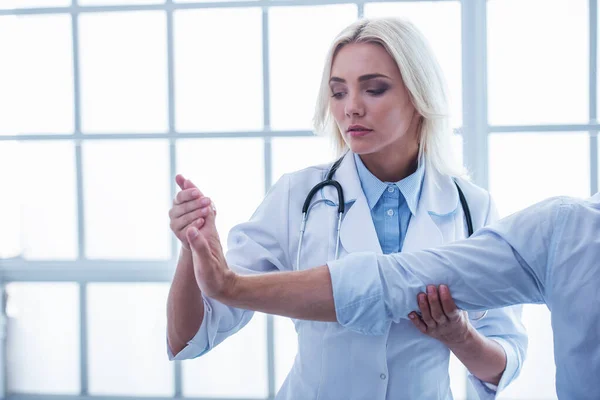 Krásný Ženský Lékař Zkoumá Pacienta Zraněnou Ruku Při Práci Své — Stock fotografie