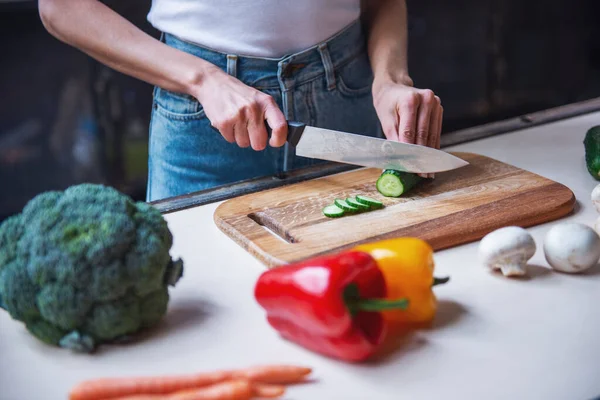 stock image Cropped image of beautiful young girl cutting vegetables while cooking in kitchen at home