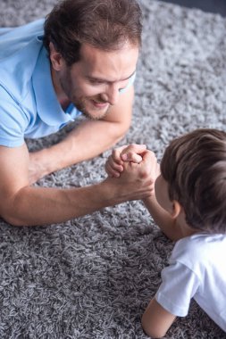 Baba ve oğul güreş ve birlikte evde vakit ise gülümseyen