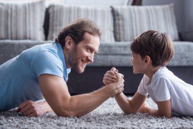 Baba ve oğul güreş ve birlikte evde vakit ise gülümseyen