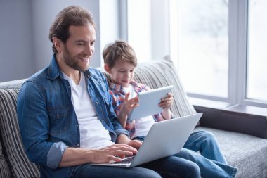 Baba ve oğul araçları kullanma ve birlikte evde vakit ise gülümseyen