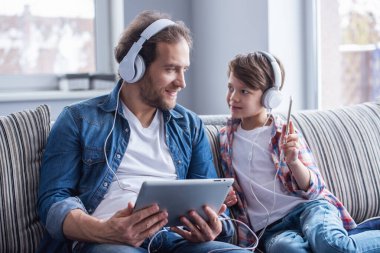 Baba ve oğul Kulaklığımda araçları kullanma ve birlikte evde vakit ise gülümseyen müzik dinleme