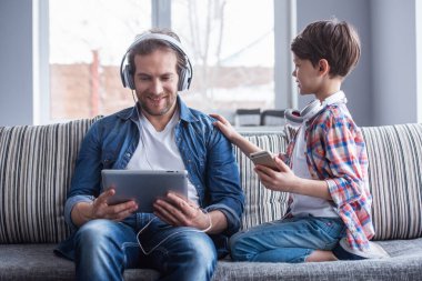 Baba ve oğul Kulaklığımda araçları kullanma ve birlikte evde vakit ise gülümseyen müzik dinleme