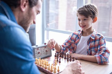 Baba ve oğul satranç oynamayı ve birlikte evde vakit ise gülümseyen