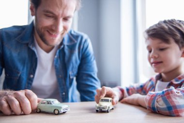Baba ve oğul oyuncak arabalar ile oynama ve birlikte evde vakit ise gülümseyen