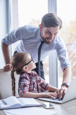 Yakışıklı işadamı ve sevimli küçük kızını bir dizüstü bilgisayar kullanarak ve birlikte vakit ise gülümseyen