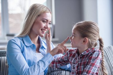 Güzel genç anne ve sevimli küçük kızı birbirlerine burun dokunmaktan ve birlikte vakit ise gülümseyen