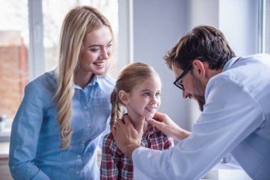 Güzel genç anne ve çocuk doktoru, küçük kızı. Doktor biraz sabırlı incelenmesi