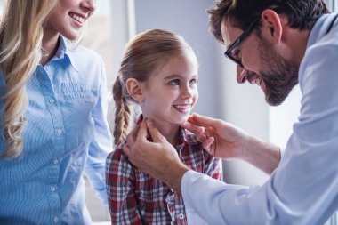 Güzel genç anne ve çocuk doktoru, küçük kızı. Doktor biraz sabırlı incelenmesi