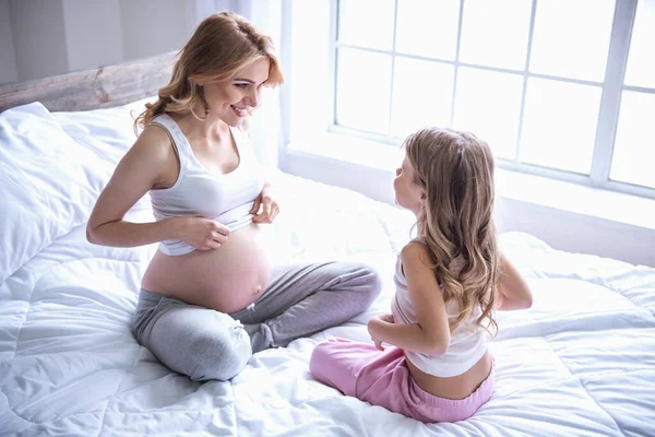 Mooie Zwangere Vrouw Haar Schattige Dochtertje Glimlachen Terwijl Samen Tijd — Stockfoto