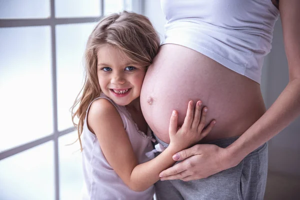 Roztomilá Holčička Její Krásná Těhotná Maminka Bříško Objímání Při Pohledu — Stock fotografie