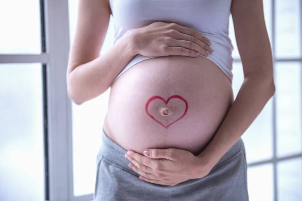 裁剪图像的美丽怀孕的女人抱着她的肚子 — 图库照片