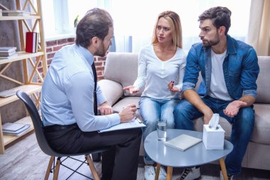 Güzel genç çift kanepede oturan ve doktor notlar yaparken psikiyatriste konuşuyor