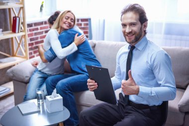 Psikolog. Güzel genç çift kanepede oturan ve doktor Ok işareti gösterilirken sarılma