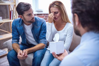 Güzel genç çift kanepede oturan ve psikiyatriste konuşuyor. Ağlayan kadın